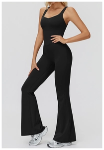 Detail view of the sleek flare leg cut and slimming fit of the black yoga jumpsuit