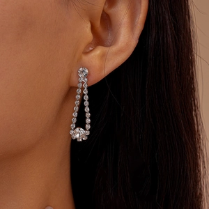 Close-up of silver long tassel drop earrings with sparkling rhinestone crystals on model