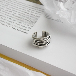 Artistic close-up of S925 sterling silver multi-layer wrap ring on open book pages