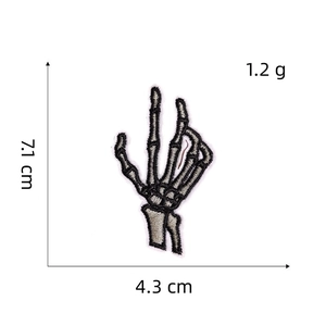 Detailed embroidery texture of a punk skull hand patch with dimensions 7.1cm x 4.3cm