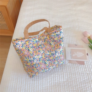 Detail of floral lunch bag with thick cotton fabric and vintage metal button closure