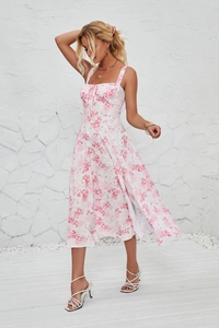 Detail of pink floral print on a white sleeveless midi dress with tie-up straps