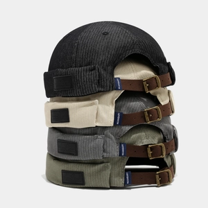 Détail de la sangle en cuir réglable et boucle en bronze sur les bonnets docker en coton