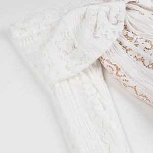 Detail of white lace embroidery texture and delicate pleated design on long dress