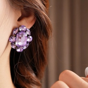 Détail de boucles d'oreilles vintage flocon de neige avec cristaux violets facettés