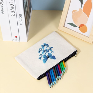 Close-up of canvas pouch with blue butterfly print holding colored pencils on a desk
