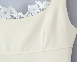 Nahaufnahme von cremeweißem Stoff mit feiner weißer Spitze und Twill-Textur-Details