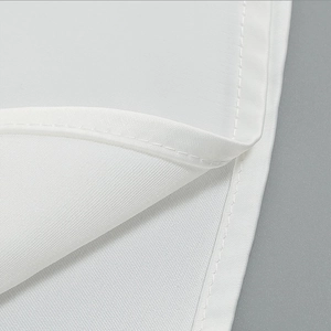 Detailed macro view of high-quality stitching and rolled hem on the white lace dress fabric