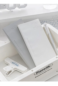 Detail of Planwith PU leather daily planners in grey and white with embossed lettering