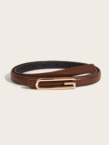 Close-up of a slim brown leather belt with a vintage gold G-shaped metal buckle