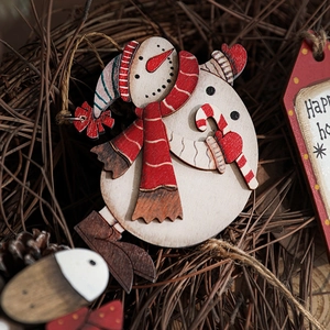 Handcrafted wooden Christmas tree ornaments featuring painted dual snowmen on pine needles