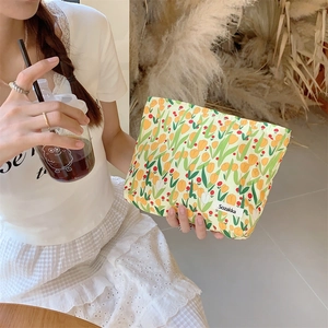 Detail of yellow tulip canvas makeup bag held in hand featuring high-quality cotton texture