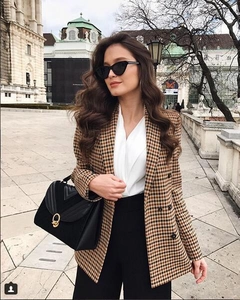 Detail of classic houndstooth blazer with double-breasted buttons in brown and black