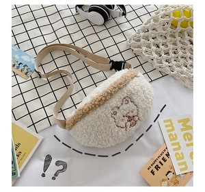Detail of cream plush teddy bear embroidery on a soft fleece crossbody bag