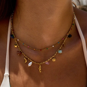 Layered bohemian gold necklace with star, moon, pearl, and colorful gemstone charms