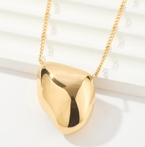 Detail shot of the polished gold irregular pendant on a minimalist necklace chain
