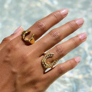18K gold plated horseshoe open ring with sparkling white diamonds on water background