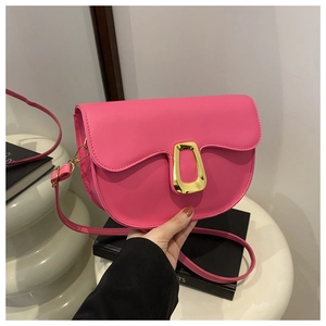 Fashionable pink PU leather saddle bag with golden hardware held by a model