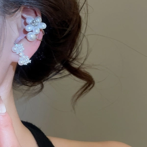 Gros plan sur d'élégants bijoux d'oreilles à fleurs en perles et zircons sur un modèle