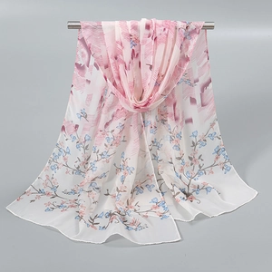 Détail d'une écharpe en mousseline à imprimé floral rose, tissu léger et drapé doux