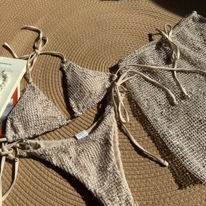 Detailed close-up of beige crochet mesh 3-piece bikini set with polyester fabric care label