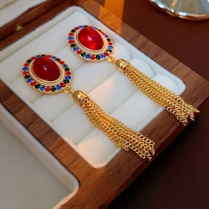 Dettaglio orecchini vintage stile palazzo con pietre rosse, nappe e strass multicolori