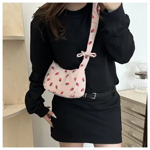 Detailed texture of pink corduroy shoulder bag with sweet strawberry patterns and bow