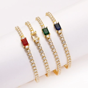 Close-up detail of elegant gold-plated bracelets with rectangular colored CZ stones