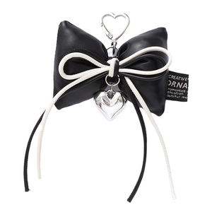 Black leather bow keychain with heart pendant and silver heart-shaped ring on white background