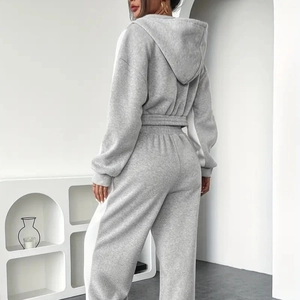 Detail view of the back of a grey knitted hoodie and high-waist joggers set on a model