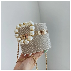 Detailed macro view of sparkling rhinestone cylinder evening bag with pearl top handle