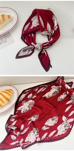 Close-up of pleated wine red floral silk scarf with rose print and zigzag edges