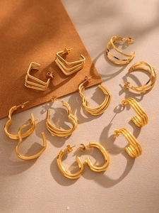 Flat lay of multiple 18K gold plated stainless steel hoop and geometric earrings
