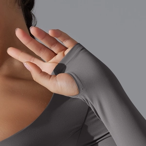 Dettaglio dei polsini con foro per il pollice su top yoga grigio scuro