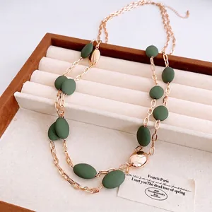 Double-layered gold chain necklace featuring olive green matte beads and polished accents