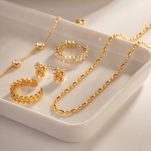Squisito set di gioielli placcati in oro 18 carati con collane e orecchini su vassoio di ceramica