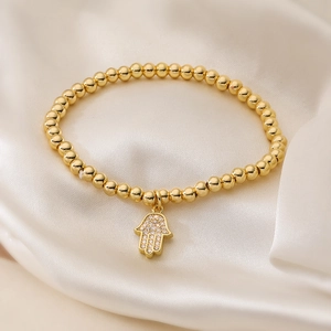 18K gold-plated beaded bracelet featuring a sparkling Hamsa Hand charm on ivory silk