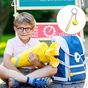 Close-up of mini wooden baseball bat keychain with yellow softball on a student backpack
