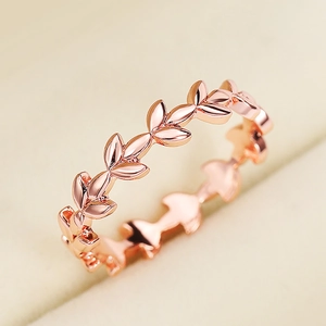 Elegante roségouden ring met wijnrankbladmotief op een beige sieradendoosje