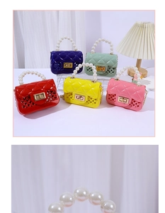 Macro detail of the elegant pearl handle and colorful jelly mini crossbody bags