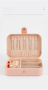 Close-up of pink PU leather jewelry box featuring necklace hooks and velvet dividers