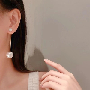 Elegant long pearl drop earrings with gold thin rod detail worn by a model