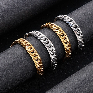 Polished gold and silver Cuban link bracelets displayed on a black cylindrical stand