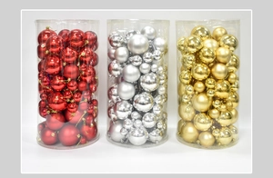 Detailed view of assorted red, gold, and silver Christmas balls in cylinder packaging