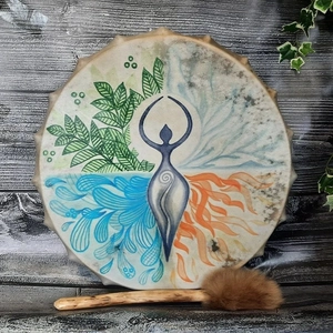 Close-up of a handmade shamanic drum with elemental artwork and a fur-headed wooden mallet