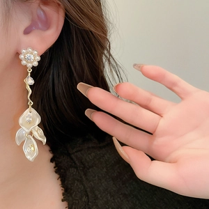 Detail of floral earrings with pearl zircon studs and hanging white flower petals