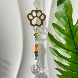 Detail of golden paw print suncatcher with faceted crystal ball and 'Made with Love' charm