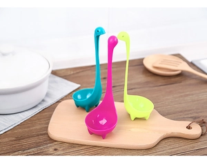 Drie Nessie-soeplepels van kunststof in blauw, roze en groen op houten plank