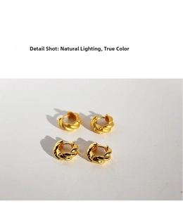 Macro detail of twisted hoop earrings in polished and matte gold finishes