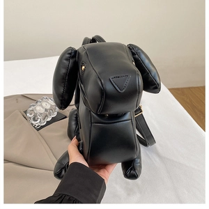 Detail view of the black dachshund dog-shaped handbag showing leather texture and zipper